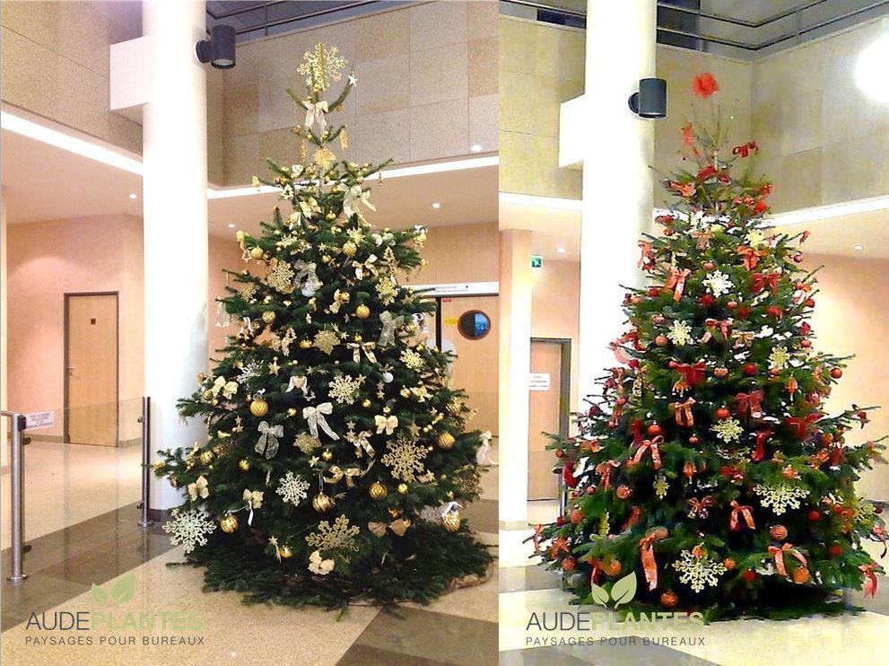 Sapins de Noël décorés or et rouge dans un hall d’entreprise